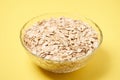 Healthy food. Muesli for breakfast. Yellow background. Bowl with flakes