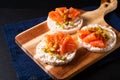 Healthy food non gluten Smoked Salmon canape Smoked salmon with rice cracker on wooden board on black slate stone Royalty Free Stock Photo