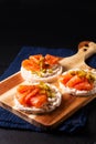 Healthy food non gluten Smoked Salmon canape Smoked salmon with rice cracker on wooden board on black slate stone Royalty Free Stock Photo