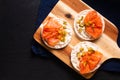 Healthy food non gluten Smoked Salmon canape Smoked salmon with rice cracker on wooden board on black slate stone Royalty Free Stock Photo