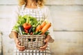 Healthy food nutrition concept and agriculture store owner concept with woman holding a bucket full of fresh vegetables - diet and