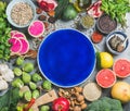 Healthy food over grey background, dark blue plate in center