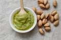 Healthy food, pistachio pasta and unpeeled salted pistachios, wooden spoon on a light background. Components for cooking