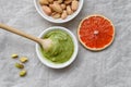 Healthy food, pistachio paste, peeled and unpeeled salted pistachios, grapefruit, wooden spoon on a light background. Components Royalty Free Stock Photo