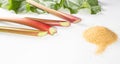 Healthy food. Rhubarb stalks and a bunch of brown sugar on a white background