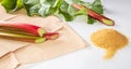 Healthy food. Rhubarb stalks and a bunch of brown sugar on a white background