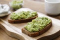 Healthy food. Rye bread with guakomole, avocado pasta on wooden cutting board. Avocado toast for breakfast Royalty Free Stock Photo