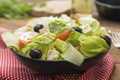 Healthy food. Salad with feta cheese, omatoes, green lettuce and black olives.. Healthy nutrition. Wooden table Royalty Free Stock Photo