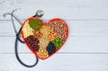 Healthy food selection clean eating for heart life cholesterol diet health concept - mixed various beans nuts grain on red heart