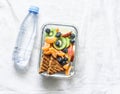 Healthy food snack sweet vitamin lunch box and bottle of clean water on a light background. Peanut butter toast, apples