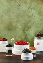 Healthy food snacks: natural dried fruits in bowls on rusty green background. Modern still life with white cubes Royalty Free Stock Photo