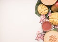 Healthy food, tropical fruits, mango, melon on a monstera leaf with smoothies on a white background, place for text flat lay