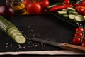 Healthy food. Vegetables on a black plate and stone cutting board and wooden background. Copy space