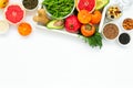 Healthy food in wooden tray: fruits, vegetables, seeds and greens on white background Royalty Free Stock Photo