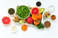 Healthy food in wooden tray: fruits, vegetables, seeds and greens on white background