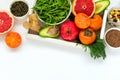 Healthy food in wooden tray: fruits, vegetables, seeds and greens on white background Royalty Free Stock Photo