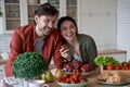 Healthy food. Young beautiful family couple, husband and wife standing in the modern kitchen at home and smiling Royalty Free Stock Photo