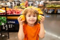 Healthy food for young family with kids. Portrait of funny little child holding shopping bag full of fresh vegetables. A Royalty Free Stock Photo