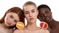 Healthy food for your skin. Three beautiful multicultural young women holding pieces of orange and grapefruit on their