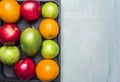 Healthy foods fresh ripe fruit, apples of different varieties, oranges, mangoes wooden box border ,text area on wooden ru Royalty Free Stock Photo