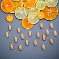 Healthy foods and medicine concept. Pills of vitamin C and various citrus fruits sliced in the shape of cloud and raining. Mixed Royalty Free Stock Photo