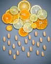 Healthy foods and medicine concept. Pills of vitamin C and various citrus fruits sliced in the shape of cloud and raining. Mixed Royalty Free Stock Photo