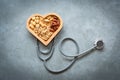 Healthy Foods. Mixed nuts in heart shape and stethoscope with nuts for diet on a concrete background. Different kinds of tasty and