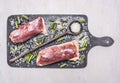 Healthy foods two raw duck breast with rice and wooden spoon for the rice on a cutting board wooden rustic background top view Royalty Free Stock Photo