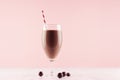 Healthy fresh chocolate smoothie with sweety and striped straw on pastel pink background, copy space.