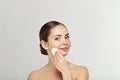 Healthy fresh girl removing makeup from her face with cotton pad. Beauty woman cleaning her face with cotton swab pad isolated on