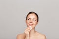 Healthy fresh girl removing makeup from her face with cotton pad. Beauty woman cleaning her face with cotton swab pad isolated on Royalty Free Stock Photo