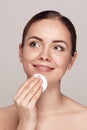 Healthy fresh girl removing makeup from her face with cotton pad. Beauty woman cleaning her face with cotton swab pad isolated on Royalty Free Stock Photo