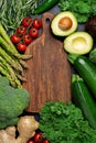Healthy fresh green vegetables and herbs around wooden cutting board for paleo diet. Royalty Free Stock Photo