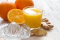 Healthy and fresh orange juice with addition of ginger on white wooden table