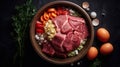 Healthy fresh pet food ingredients on a rustic floor including raw meat in a bowl, a large bone, vegetables , eggs and grains.