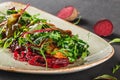 Healthy fresh salad with baked beets, greens, arugula, spinach and croutons in plate over dark table. Healthy vegan food Royalty Free Stock Photo