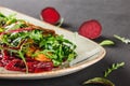 Healthy fresh salad with baked beets, greens, arugula, spinach and croutons in plate over dark table. Healthy vegan food Royalty Free Stock Photo