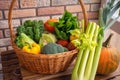 Healthy fresh vegetables and fruits in willow basket on wooden background Royalty Free Stock Photo