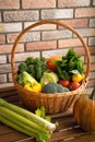 Healthy fresh vegetables and fruits in willow basket on wooden background Royalty Free Stock Photo