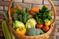 Healthy fresh vegetables and fruits in willow basket on wooden background Royalty Free Stock Photo