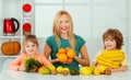 Healthy fruit for kids. Happy children and mother with fruits in kitchen, kids healthy eating concept. Family eating Royalty Free Stock Photo