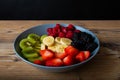 Healthy fruit salad in a greyblue plate on wood antique table and retro blue tablecloth