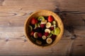 Healthy fruit salad in a wood plate on wood antique table and retro blu tablecloth