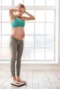 Healthy future mother measuring her weight Royalty Free Stock Photo