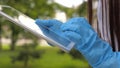 A healthy girl is walking in medical gloves working with a tablet in a city park. close-up. COVID-19. danger of virus Royalty Free Stock Photo