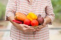 Healthy grandmother holding fresh vegetable and fruit