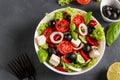 Healthy Greek salad of green lettuce, cherry tomato, onion, pepper, feta cheese, black olives, basil, cucumbers, with olive oil