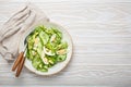 Healthy green avocado salad bowl with boiled eggs, sliced cucumbers, edamame beans, olive oil and herbs on ceramic plate Royalty Free Stock Photo