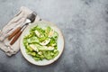 Healthy green avocado salad bowl with boiled eggs, sliced cucumbers, edamame beans, olive oil and herbs on ceramic plate Royalty Free Stock Photo