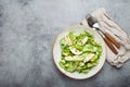 Healthy green avocado salad bowl with boiled eggs, sliced cucumbers, edamame beans, olive oil and herbs on ceramic plate Royalty Free Stock Photo